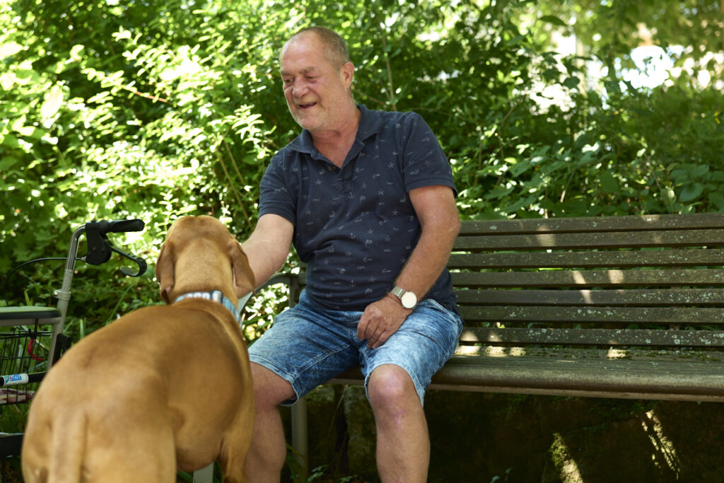 Älterer Herr füttert Hund