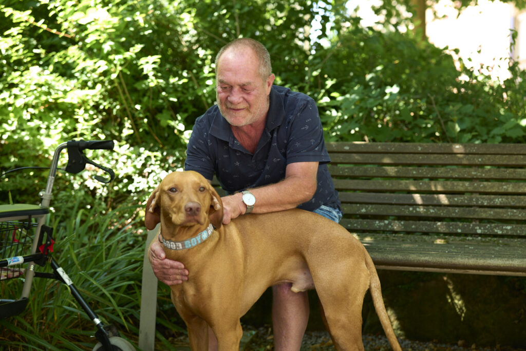 Senior streichelt Hund